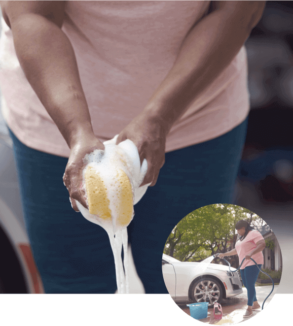 Woman Squeezing a Sponge to Wash a Car