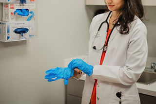 Female doctor putting on second glove