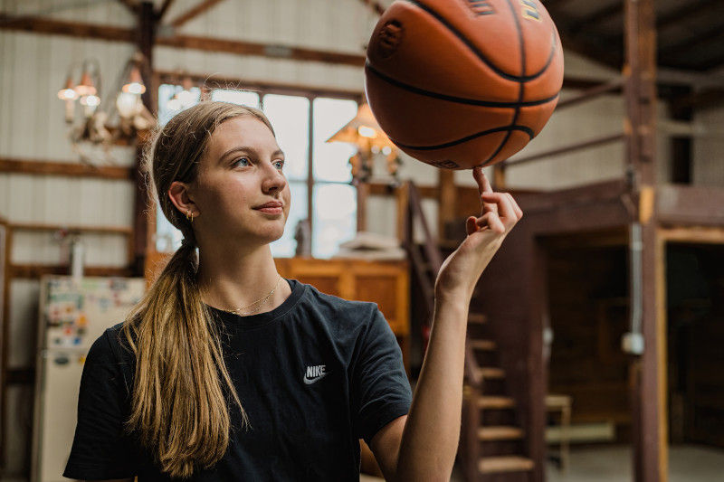Basketballspielerin balanciert einen Ball auf dem Zeigefinger