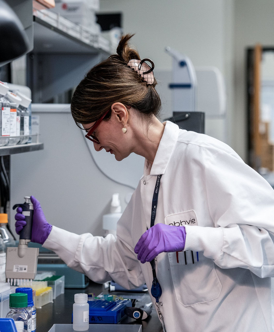 Woman in lab using equipment and wearing a lab coat