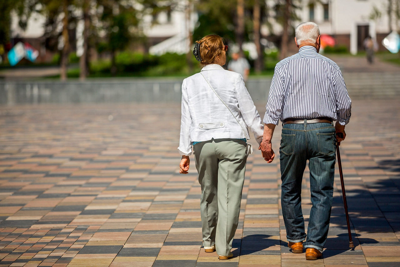 Older couple walking together holding hands