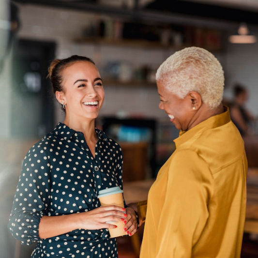 Zwei Frauen lachen im Kaffee