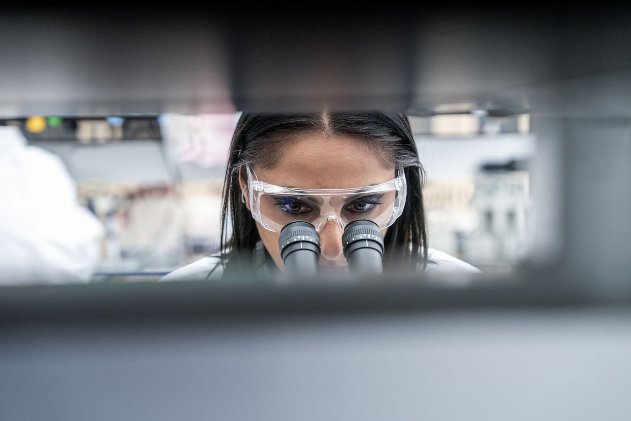 Image d'une personne regardant dans un microscope, illustrant l’engagement d’AbbVie en tant que société pharmaceutique dans l’innovation. Travailler chez AbbVie est synonyme d’opportunités enrichissantes.