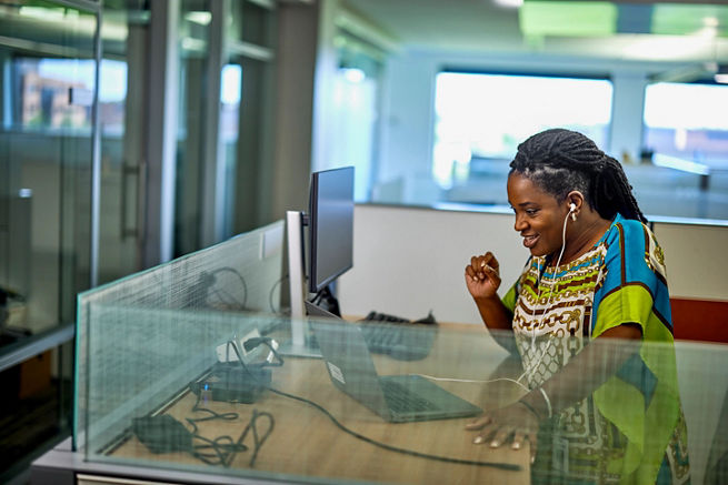femme debout à un bureau regardant un ordinateur