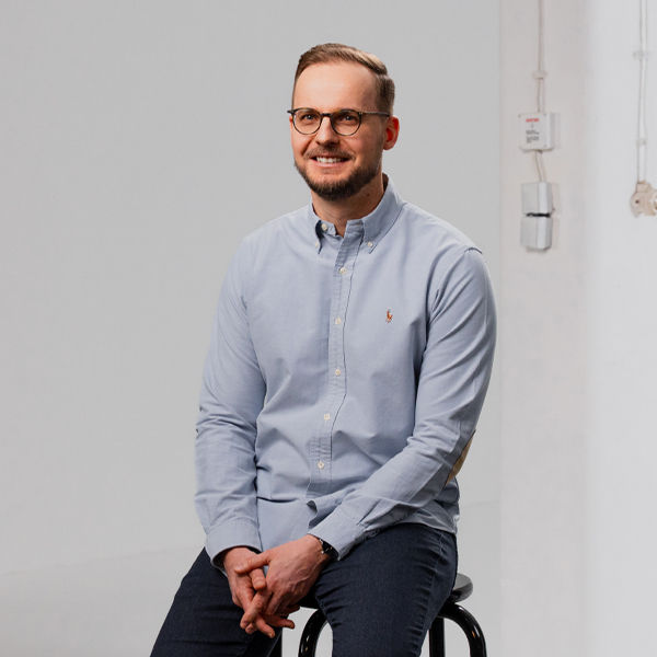 Frank, Lead Market Access im Bereich Oncology sitzt auf einem hohen Hocker.