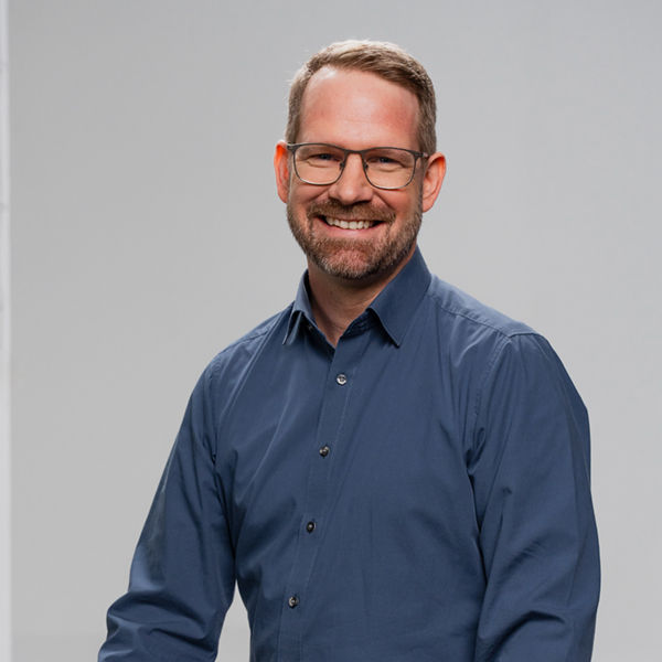 Malte, Negotiation Lead sitzt auf einem hohen Hocker