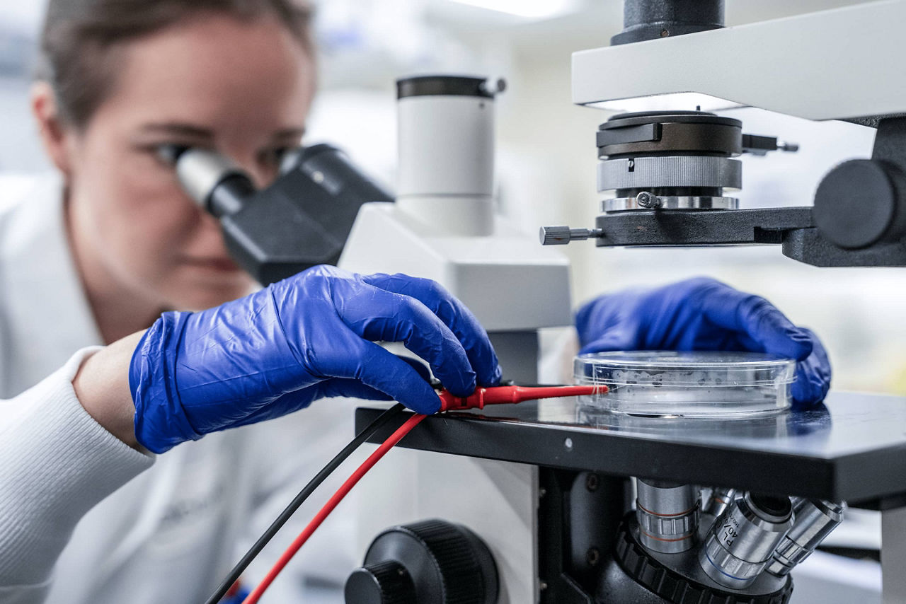 femme regardant un échantillon au microscope