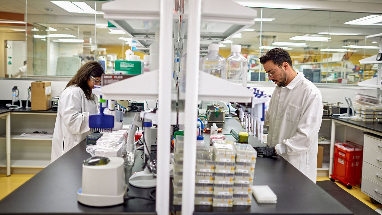 deux employés discutant en blouse de laboratoire
