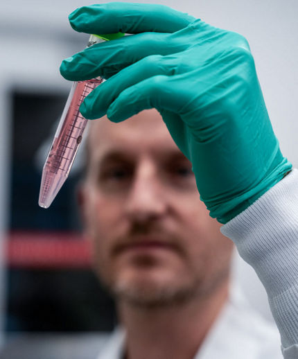 man looking at test tube