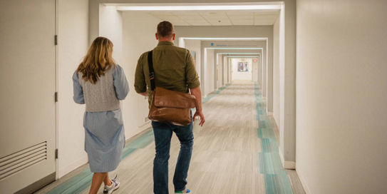 man and woman walking down hall