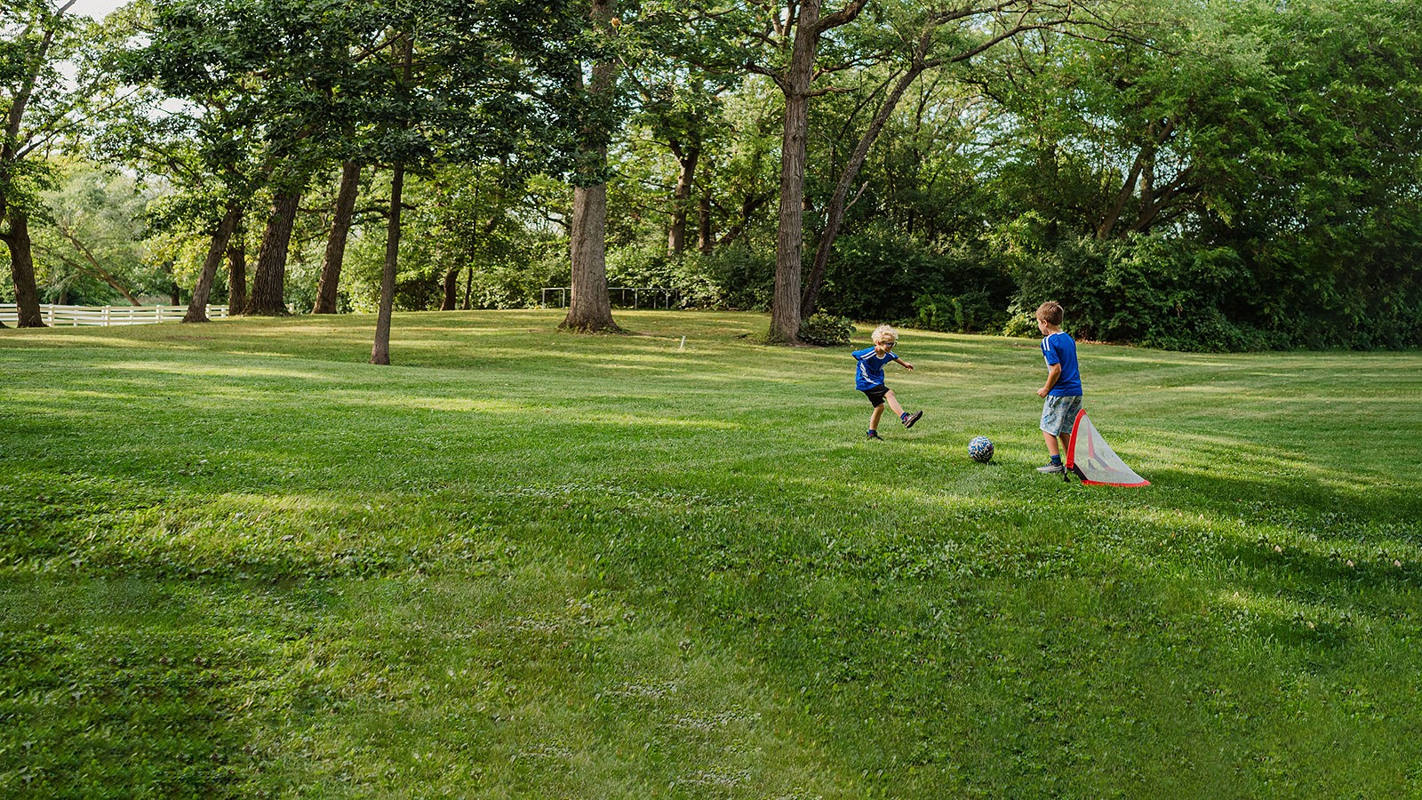 two kids playing soccer outside