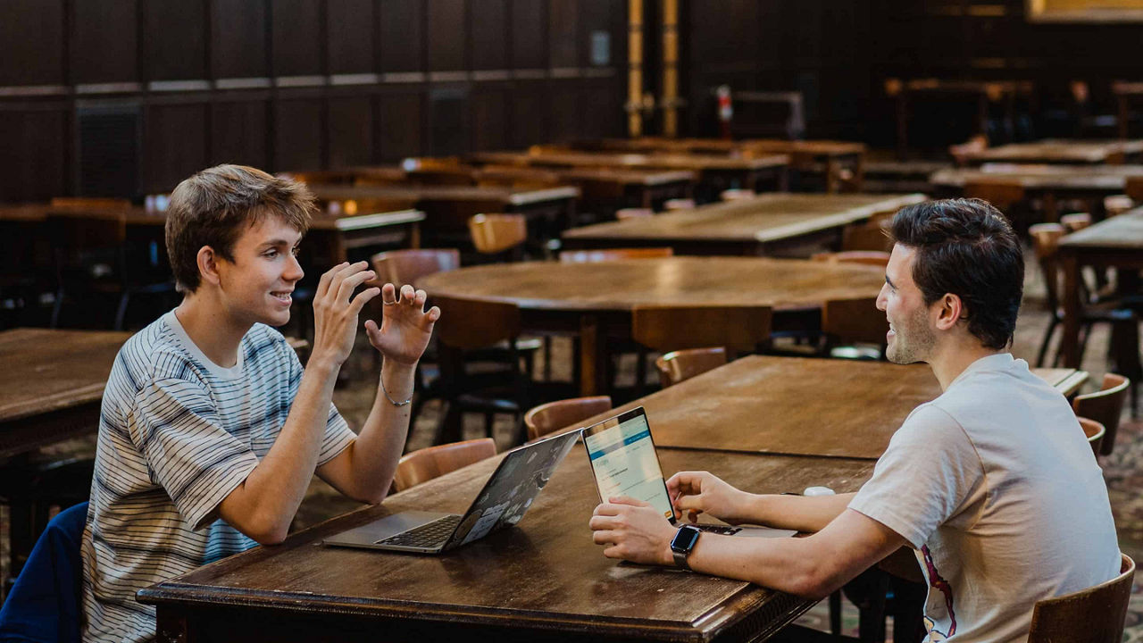 Zwei Studenten reden in der Bibliothek