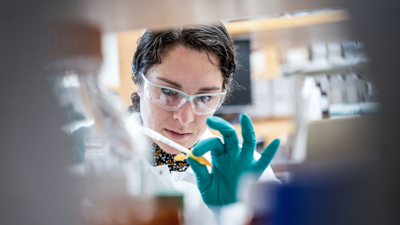 Labormitarbeiterin hält eine Pipette